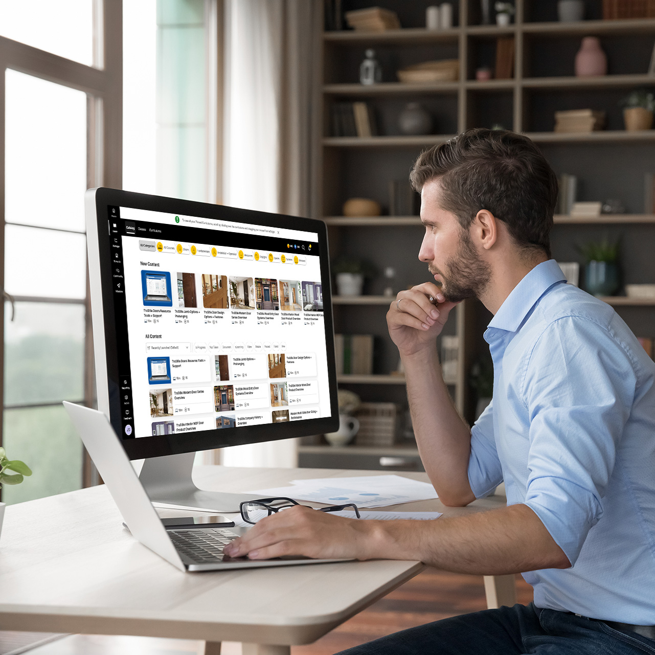 man on a desktop computer looking at elearning courses